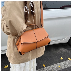 Caramel leather geometric puzzle bag styled with an autumn trench coat on street