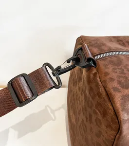 Dettaglio del gancio della tracolla resistente su borsa da viaggio leopardata