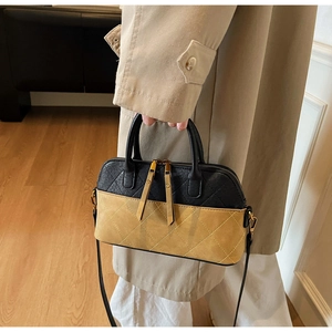 Detail of contrast color quilted shell bag with zipper and gold hardware details