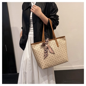 Détail d'un grand sac cabas beige à motifs quadrillés marrons avec foulard léopard