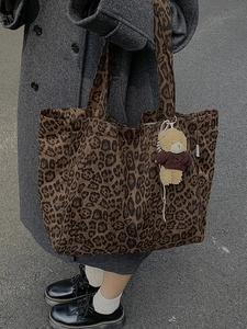 Leopard print canvas tote bag with bear charm shown on model in street style setting