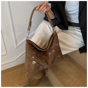 Détails du sac demi-lune en daim marron foncé avec ornements d'oeillets argentés stylés