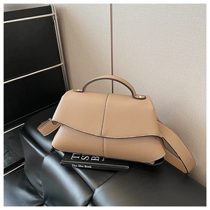 Detail of khaki pebbled leather handbag with geometric flap and wide shoulder strap