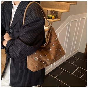 Détail du sac cabas en daim marron café avec œillets métalliques et bandoulière en cuir