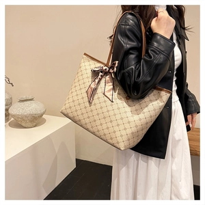 Détail d'un grand sac cabas crème avec imprimé géométrique et foulard en soie rose
