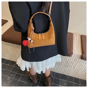 Sac porté épaule en cuir mat marron avec poignée cylindrique et pompons décoratifs