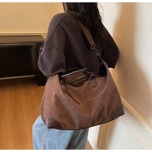 Vista dettagliata di una grande borsa tote in pelle scamosciata marrone scuro indossata