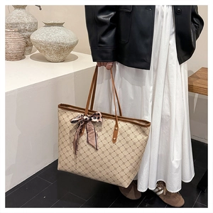 Détail d'un grand cabas beige avec motifs géométriques et foulard en soie décoratif