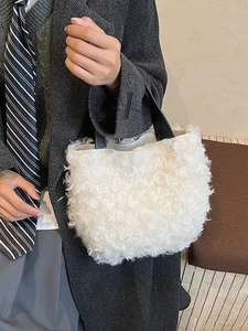 Borsa a secchiello in peluche bianca con texture rosa e manici neri abbinata a cappotto retrò