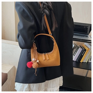 Sac croissant en daim marron avec breloques en peluche et bandoulière en cuir en situation