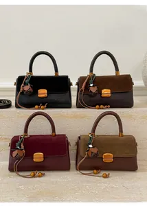 Four retro-colored crossbody bags displayed on steps with metal buckles and tassel charms