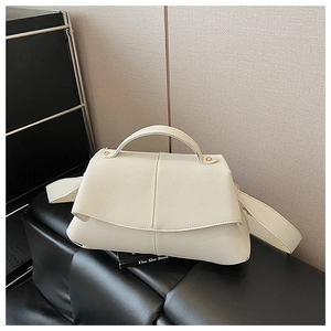 Detail of creamy white litchi pattern leather bag with wide strap and gold hardware