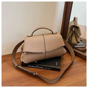 Detail of khaki pebbled leather handbag with top handle and adjustable shoulder strap