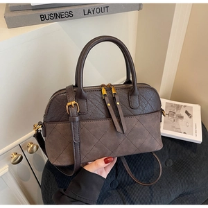 Detail of vintage brown shell bag with diamond stitching and double zipper closures