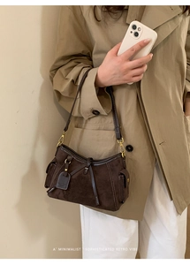 Detailed view of deep brown suede tote with retro drawstring and gold-tone hardware