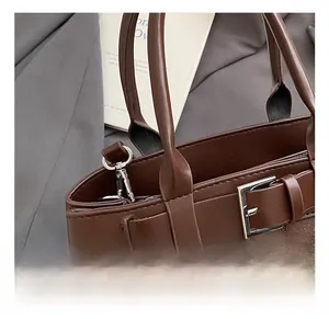 Close-up of dark brown bag showing mixed leather textures and silver metal buckle detail