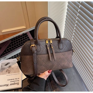 Detail of vintage rhombic pattern handbag with dual zippers and dark brown matte finish