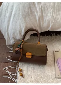 Detail of dark brown leather and olive green suede handbag with golden square lock
