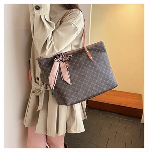 Détail d'un sac cabas vintage avec motif géométrique et accessoire élégant en foulard de soie