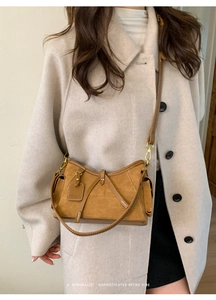 Brown faux suede trapezoid crossbody bag styled with a beige wool coat for a chic look