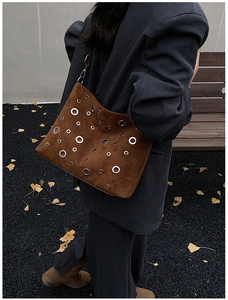 Sac bandoulière en daim marron avec œillets argentés dans un look mode de rue