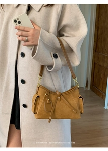 Close-up of retro brown suede tote bag with side pockets and elegant bow tie details