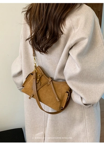 Brown suede tote bag with retro belt buckle detail shown on beige coat outfit