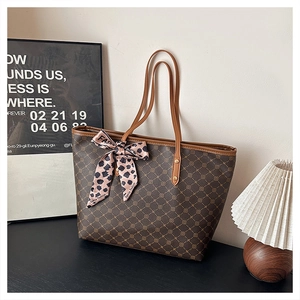 Détail d'un grand sac cabas vintage marron avec motif géométrique et foulard léopard