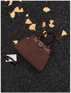 Brown frosted suede handbag shown on autumn road with ginkgo leaves and sunglasses