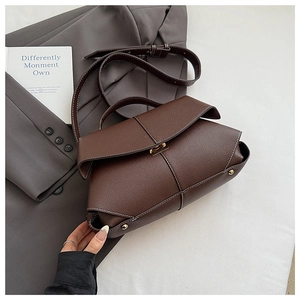 Detail of dark brown leather handbag featuring contrast stitching and gold twist-lock buckle
