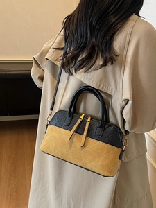 Vintage color-block crossbody bag with rhombic stitching and tassels in high-end studio setting