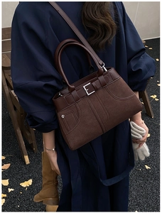 Detail view of the vintage dark brown handbag featuring leather stitching and buckle
