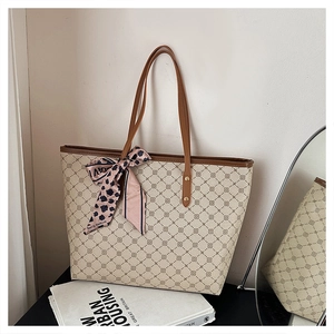 Détail d'un sac cabas beige à motif géométrique et foulard décoratif en soie léopard