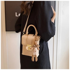 Detail of beige rectangular phone bag with gold twist lock and plaid rabbit charm