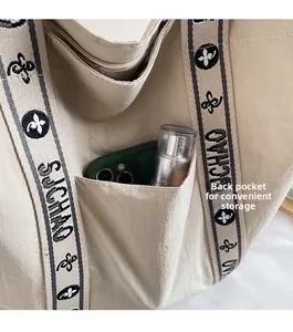 Detailansicht der beige Canvas-Tasche mit praktischer Tasche auf der Rückseite für Stauraum