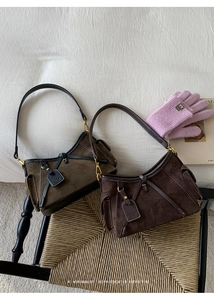 Detailed view of suede tote bags with contrast stitching and retro buckle accents