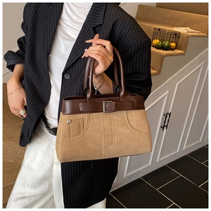 Detail of retro dual-tone handbag with belt buckle and decorative stitching detail
