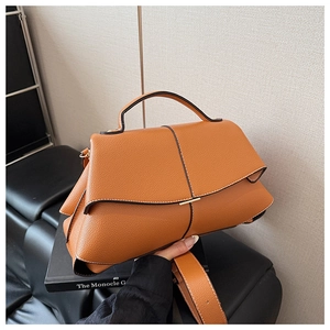 Close-up of caramel lychee grain leather handbag with minimalist metal buckle detail