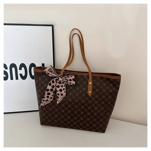 Détail d'un sac cabas à carreaux marron avec foulard léopard et poignées fines