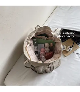 Geräumiger beiger Canvas-Shopper mit Laptop und Alltagsutensilien in der Draufsicht