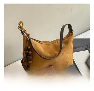 Detail of suede hobo bag with wood bead charms and metallic zipper finish