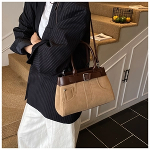 Close-up of retro camel suede tote bag with dark brown leather straps on a model