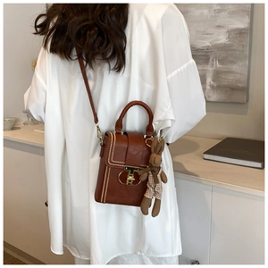 Brown PU leather crossbody phone bag with vintage gold clasp and rabbit charm on model