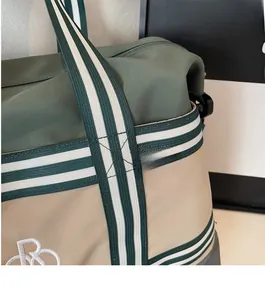 Détail du sac de voyage vert olive montrant le tissu en nylon imperméable et les sangles robustes