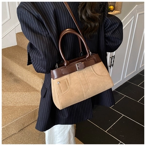 Detail of vintage beige matte handbag with brown leather trim and silver rivets