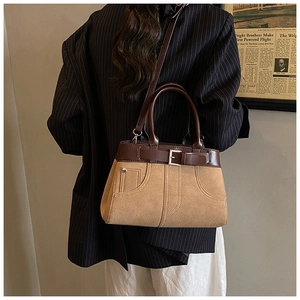 Detail of vintage two-tone crossbody bag with contrast leather buckle and soft suede texture