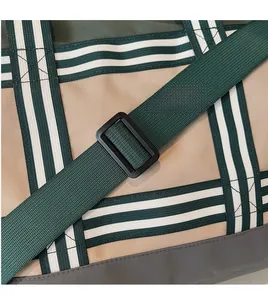Gros plan sur la bandoulière rayée réglable et les boucles du sac fourre-tout