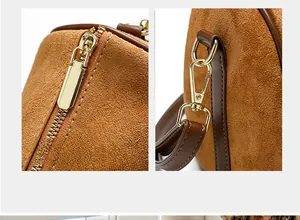 Detail of smooth gold metal zipper and D-ring on brown frosted leather pillow bag