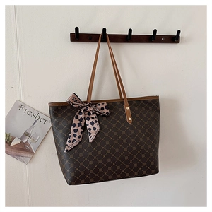 Détail du sac cabas marron vintage avec motif géométrique et foulard léopard sur l'anse