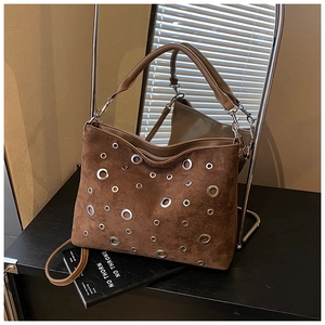 Vue détaillée du sac hobo en daim marron avec décorations d'œillets métalliques argentés